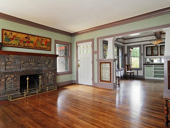The beautiful Craftsman interior has been retained, with built-ins and exposed brick. The living room and dining room are connected through a pillared, stained glass breezeway.