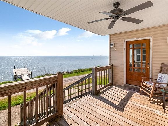 Wooden deck with a water view and ceiling fan