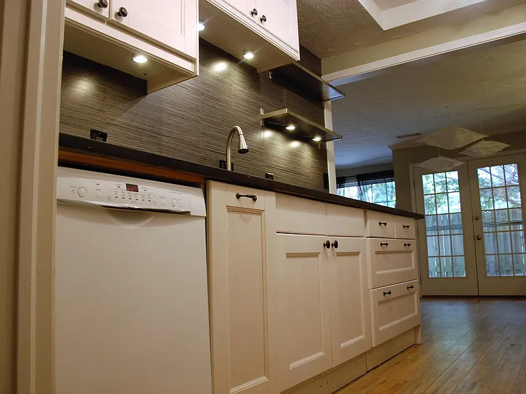 Low angle view of dishwasher and sink in kitchen.