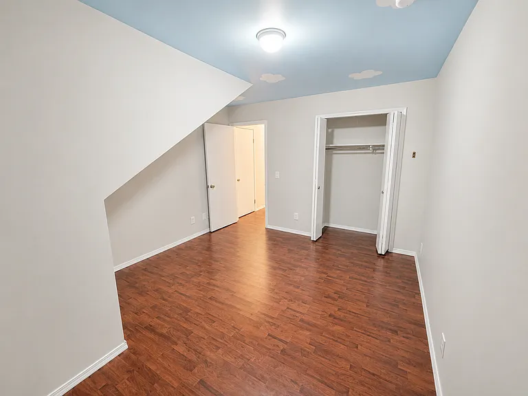 Third Bedroom - 
Charming third bedroom featuring hardwood-style flooring, a spacious closet, and unique architectural details that create a cozy and functional living space.