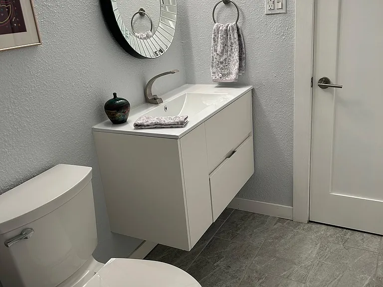 Floating vanity with soft close drawers and door provide additional storage. Chair height toilet