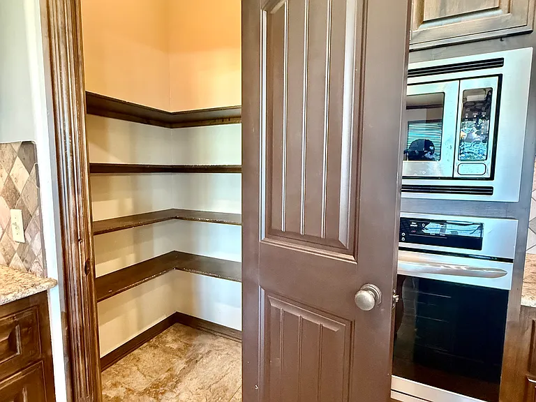 Very roomy pantry with four shelves and large space from the floor to the first shelf. Makes for easy storage for bigger bulky items.