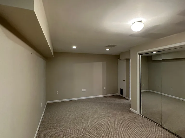 Second room in finished basement excellent for home gym, art studio, home office. Mirrored closet with custom shelves.