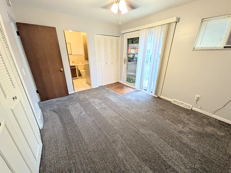 Bedroom with new carpet and paint. Back sliding door leads to private parking.