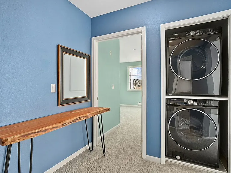 Hallway with modern stacked washer and dryer in-unit