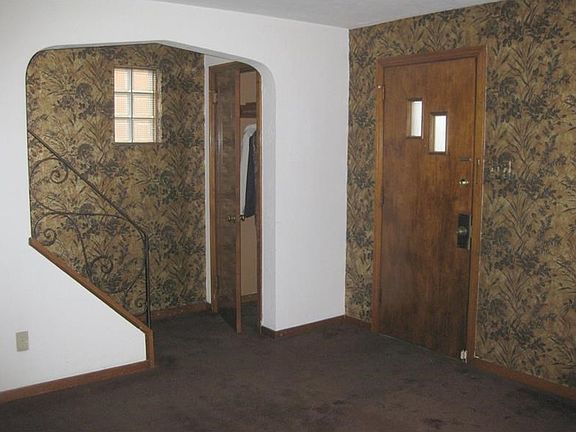 Foyer area with guest closet.  Glass block window lets in light but maintains privacy.