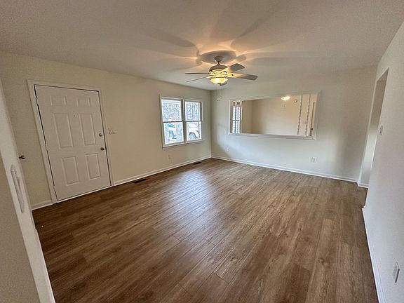 Another view of the entryway and living room from the hallway. The opening on the right leads to the kitchen.
