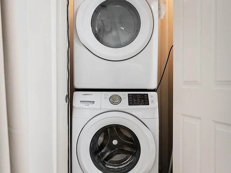 Convenient in-home laundry closet with a stacked washer and dryer for easy day-to-day living.