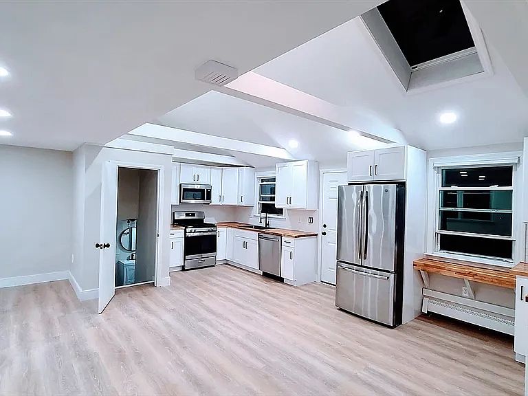landlord's photo: open-concept kitchen / living area (with skylight), with mid-level bathroom door open