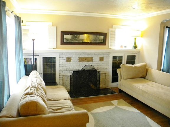 Cozy living room with original fireplace with built in surround.