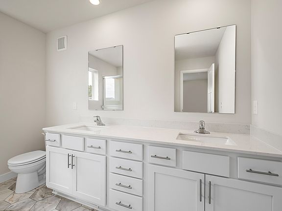 The master bathroom has a dual sink vanity.