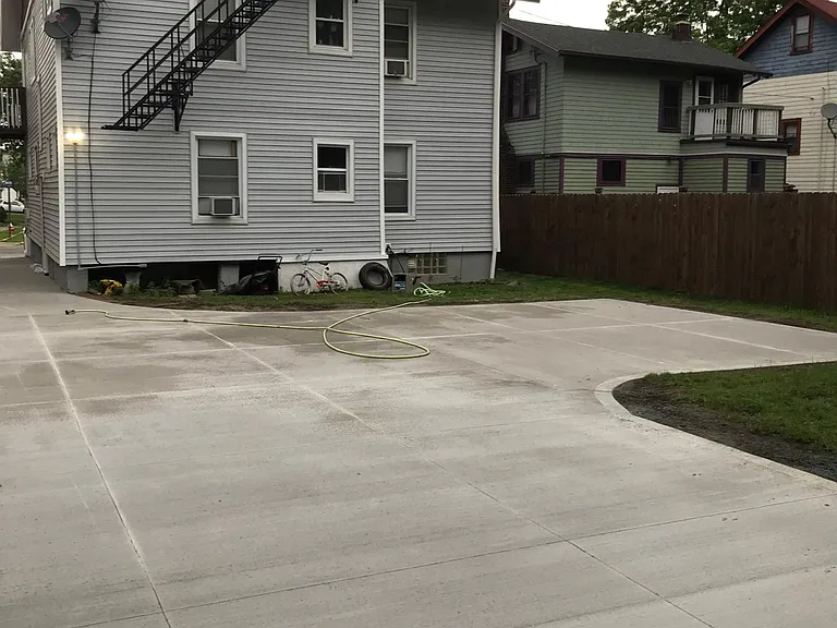 Rear view of property. Third floor apartment is at the very top with small porch leading to fire escape. One year old concrete driveway