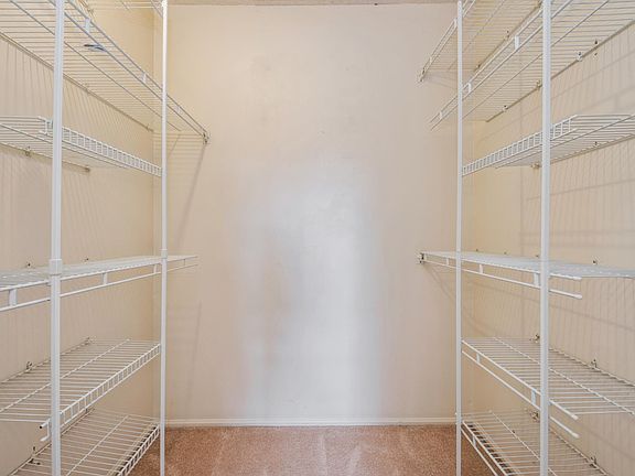 Primary walk-in closet with custom shelving unit.