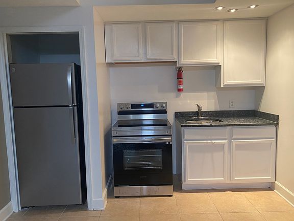 Kitchen has a fridge/freezer, standard electric stove and oven