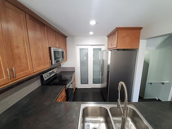 Sleek, functional Kitchen with great lighting , large pantry with custom order doors, snew tainless steel appliances includingside by side fridge