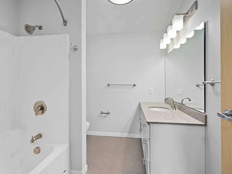Bright, modern bathroom featuring sleek fixtures, a spacious vanity, and a cozy tub, perfect for relaxation. Bright, modern bathroom featuring sleek fixtures, a spacious vanity, and a cozy tub, perfect for relaxation.