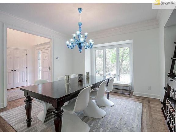 Dining room with unique custom chandelier with bump out for buffet. Inlaid hardwood detailing.