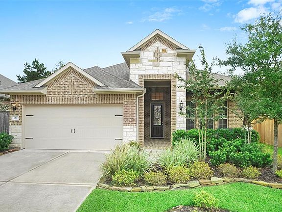 Brick and Stone exterior with professional landscaping and covered front porch.