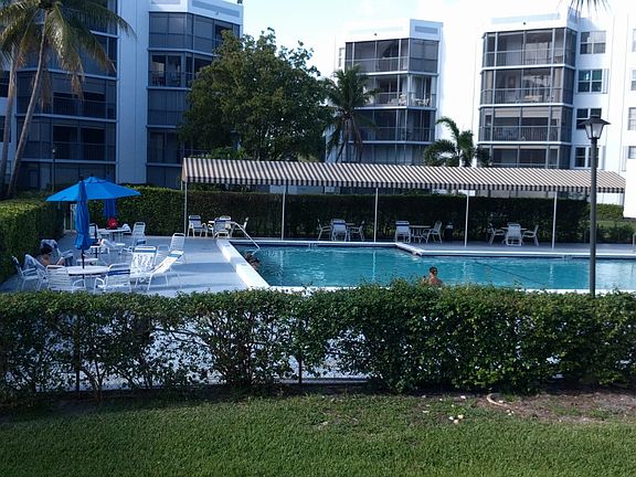 Relaxing tree lined pool area with comfortable shaded seating and plentful green space.