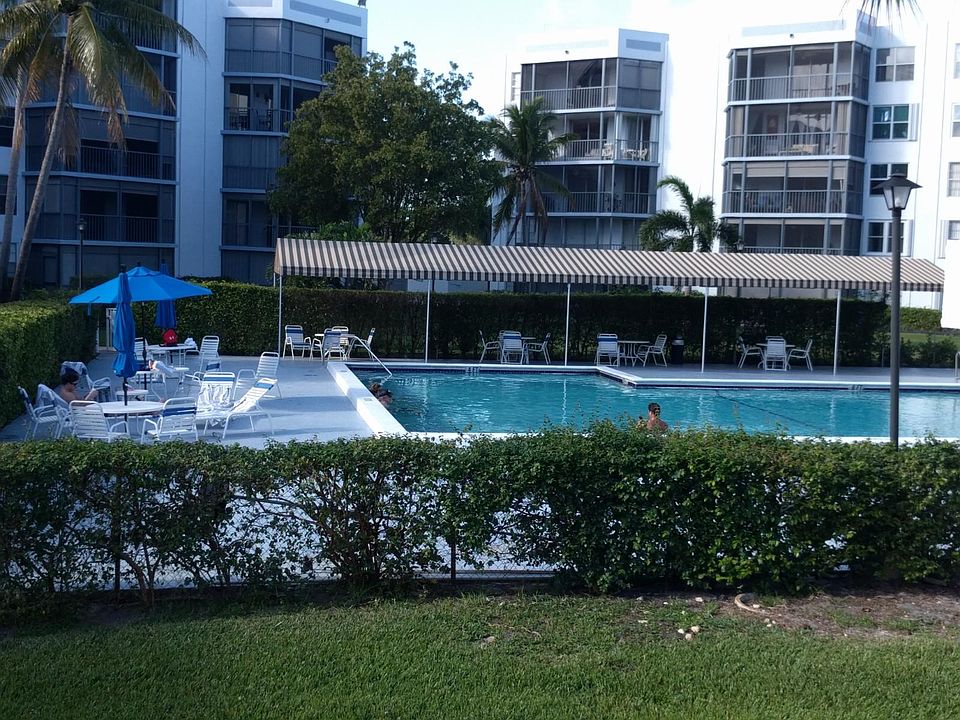 Relaxing tree lined pool area with comfortable shaded seating and plentful green space.