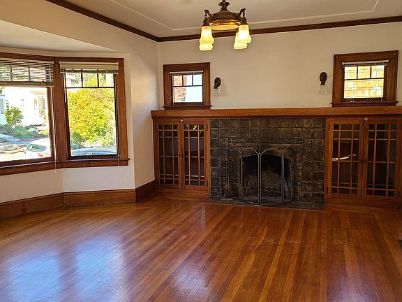 Living room with dramatic stone fireplace flanked by wood and glass cabinets.