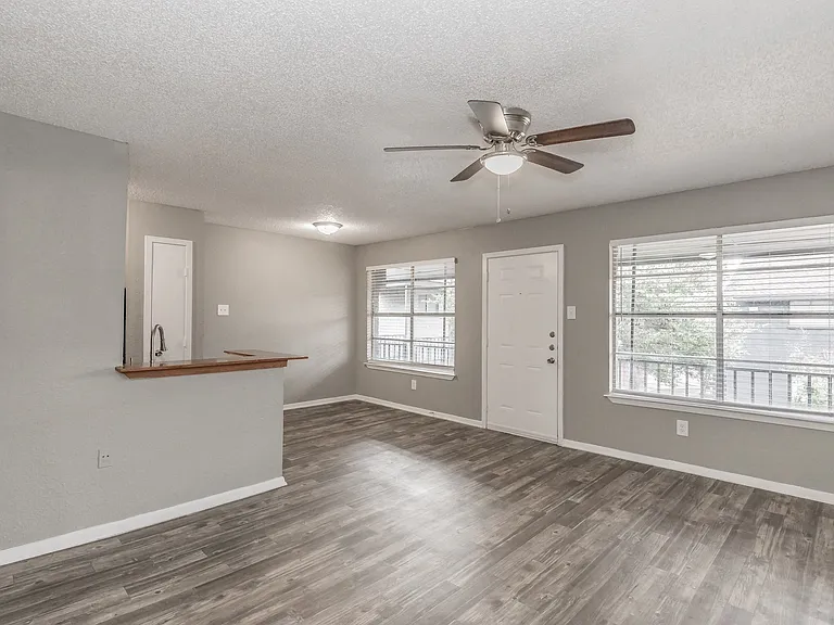 Spacious living areas feature natural light and wood-style flooring at Chapel Creek Apartments.