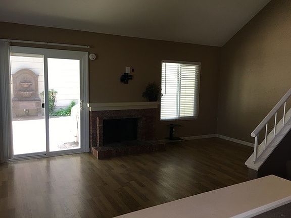 living room with view to outdoor fountain and pavers in backyard