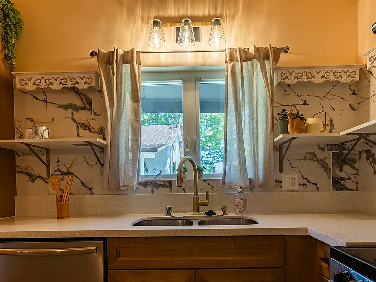 Open shelf space and stainless steel sink. Glacier Bay pull down faucet. Frigidaire Gallery dishwasher. Split window opens outwards for great air flow.