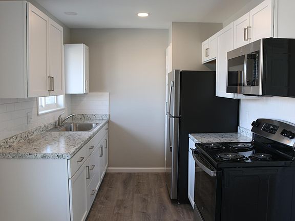 Kitchen includes new GE stainless steel appliances, white shaker cabinets with brushed nickel pulls and subway tile backsplash.