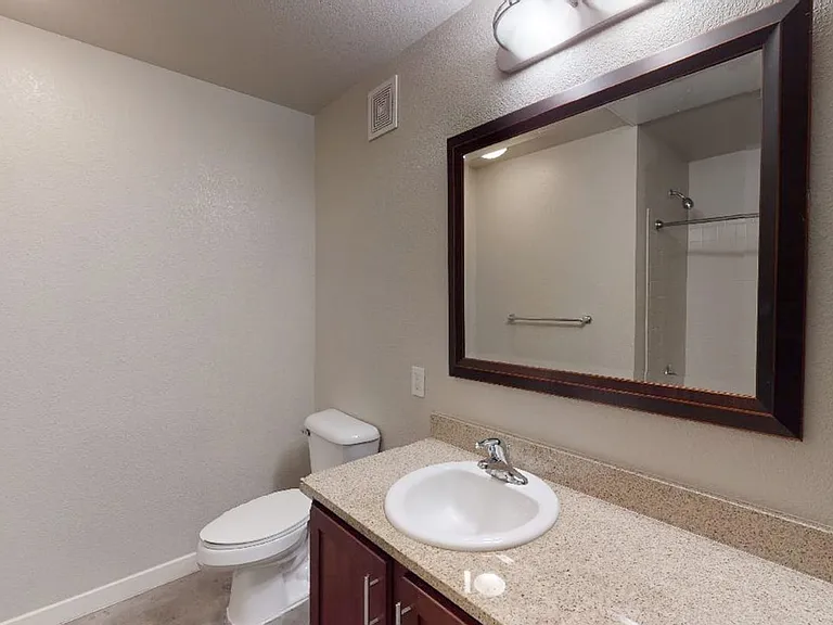 Apartment bathroom with polished concrete flooring.