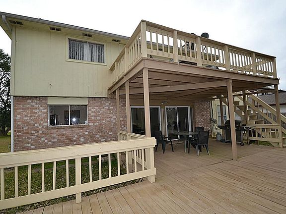Back view of house offering a large decked patio and balcony overlooking Oyster Creek.