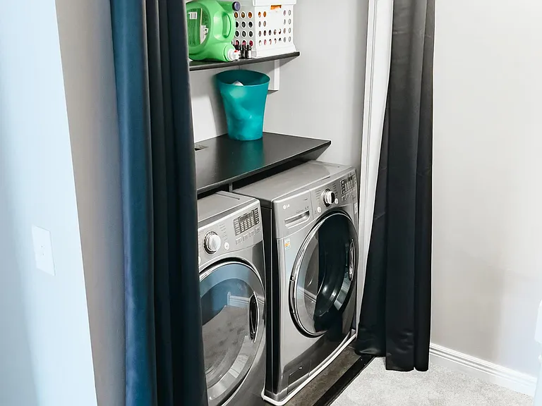Upper level laundry with large front loaders and shelving.