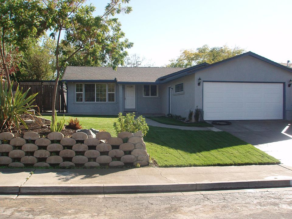 Street view - two-car garage, lawn and raised planter
