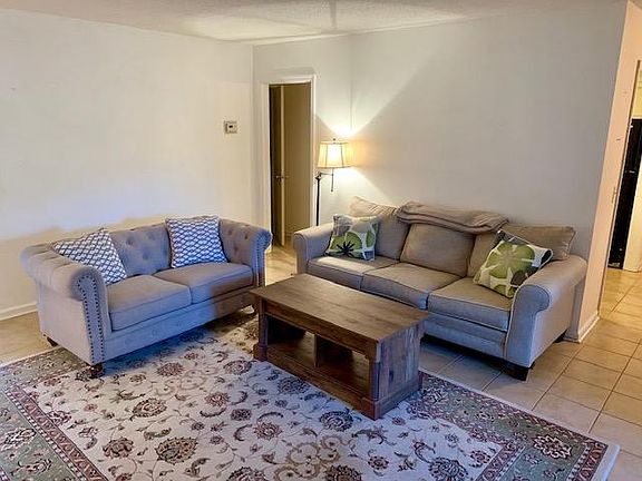 Other angle of living room - Around right corner is entrance to dining space and kitchen. Door in the middle goes to a half bath. (Photo taken while furnished)