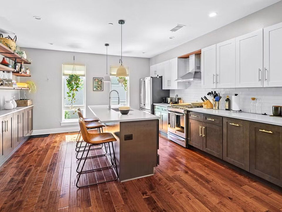 Gourmet kitchen with modern appliances and custom wood shelving.