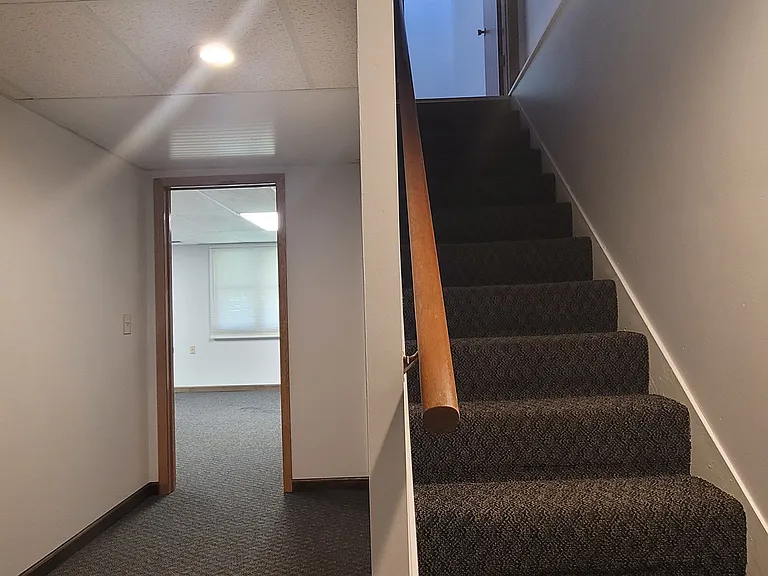 Walk-out basement view showing the third bedroom entrance and staircase to the ground level.