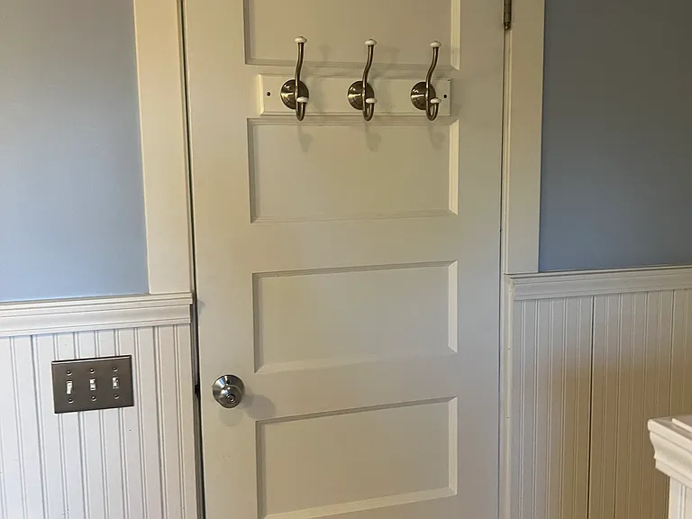 Inside of Bathroom Door adorns three satin nickel hooks for hanging