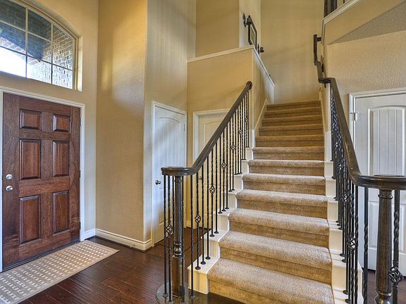Such a pretty entry with wood floors running through the family room and dining room and iron ballus