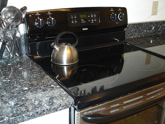 Kitchen with Granite Countertops, Stainless Steel Appliances, and Marble Tiles