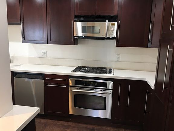Updated kitchen with quartz counter tops that feature stainless steel gas range with microwave hood & dishwasher