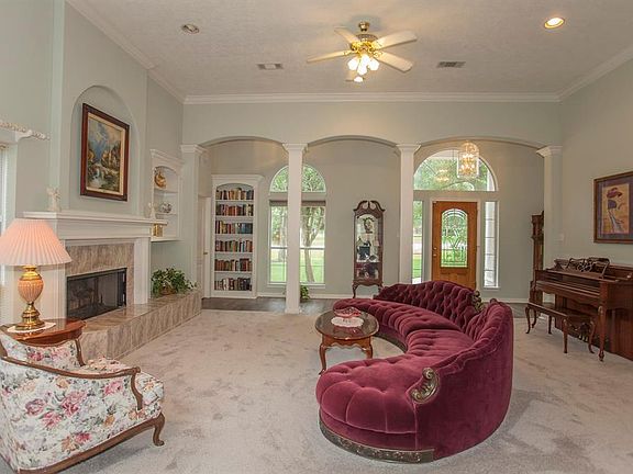 This view of the front door from the living area and the entry hallway. Note the beautiful arched columns and high ceilings. There are 2 built-in bookcases in this area.