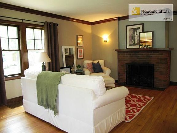 Formal living room w/ exceptional hardwoods, brick fireplace & o