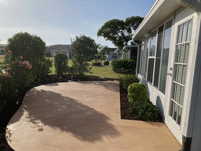 Concrete garden patio and door to enclosed lanai