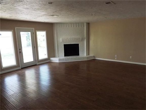 Spacious and open family room with new laminate wood floors and wood burning fireplace