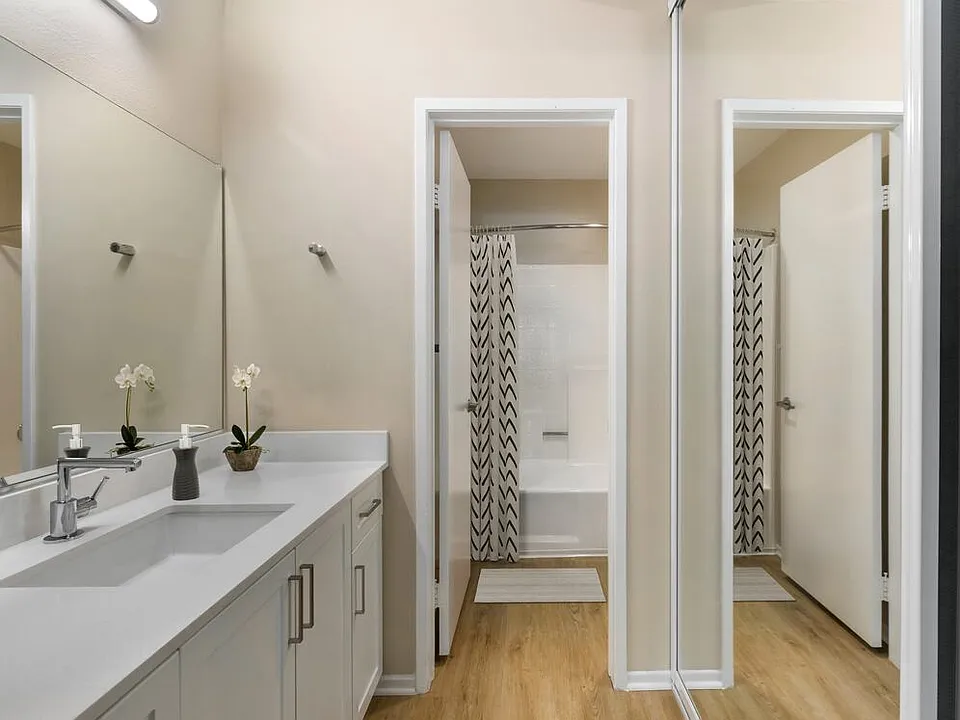 Renovated Package II bath with white quartz countertops, white cabinetry, and hard surface flooring