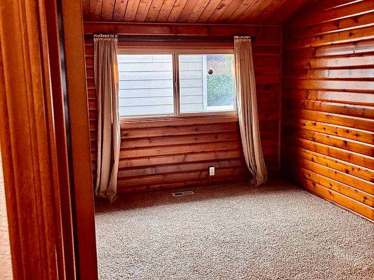 Bedroom Two with natural wood logs.