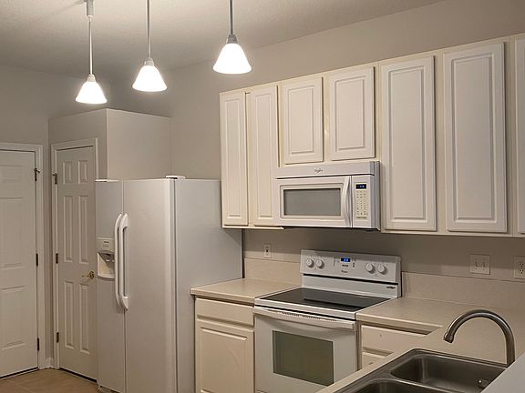 kitchen with pantry, refrigerator, microwave, oven, and dishwasher