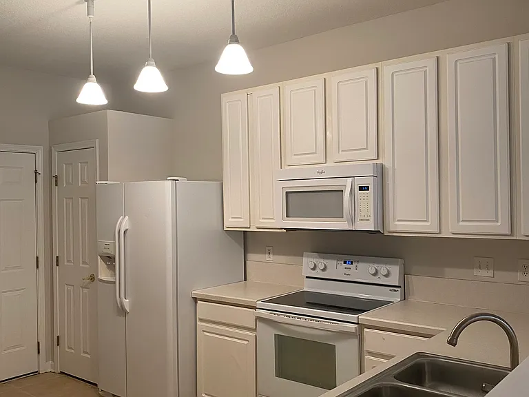 kitchen with pantry, refrigerator, microwave, oven, and dishwasher