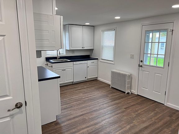 Kitchen door to side entrance on the right and door to 3rd bedroom stairs on the left