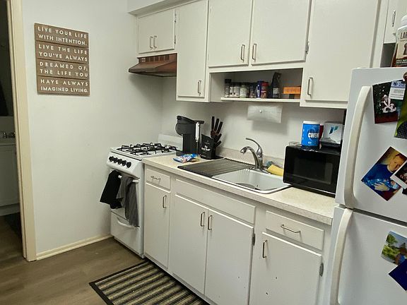Kitchen with plenty of storage space with stove, refrigerator and microwave
